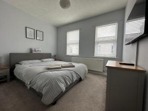 吉斯伯勒Cosy, 2 Bedroom Cottage in Guisborough Town Centre的一间卧室设有一张大床和两个窗户。