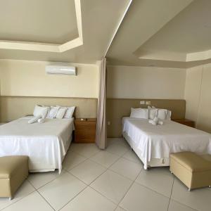 萨尔瓦多蒙特雷酒店的一间卧室配有两张带白色床单的床