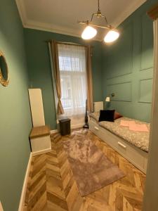 布达佩斯PJ apartment的一间卧室设有绿色的墙壁、一张床和窗户