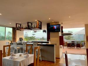 坎帕拉Arcadia Suites - Kampala的一间带桌椅和电视的用餐室