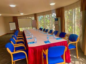 坎帕拉Arcadia Suites - Kampala的一间会议室,配有长桌子和蓝色椅子