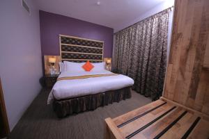 坎帕拉Arcadia Suites - Kampala的一间卧室设有一张大床和紫色的墙壁