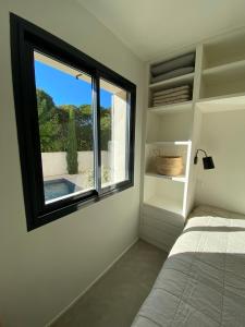 马洛塞讷STUDIO in res. LES CYCLISTES的一间卧室设有一张床和一个美景窗户。