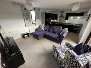 蒂斯河畔斯托克顿2 Bedroom Riverside Property with Roof Terrace的一间带紫色沙发的客厅和一间厨房