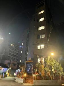 首尔The garden hotel的一座高大的建筑,晚上有标志