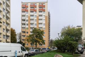 波兹南Apartament Turkusowa- z widokiem na korony drzew的停在高楼前的白色货车