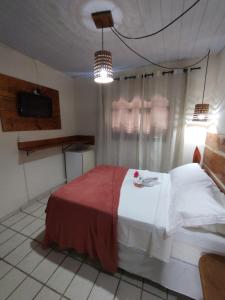 皮帕Pousada Mar e Sol的一间卧室配有一张床和一台电视。