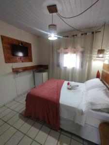 皮帕Pousada Mar e Sol的一间卧室配有一张床和一台电视