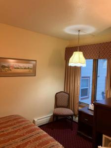西沃德苏厄德酒店的酒店的客房 - 带一张床、椅子和窗户