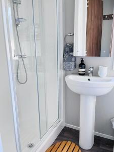 爱丁堡Lovely 3 bedroom holiday home in Seton Sand caravan park Wi-Fi Xbox的浴室配有白色水槽和淋浴。