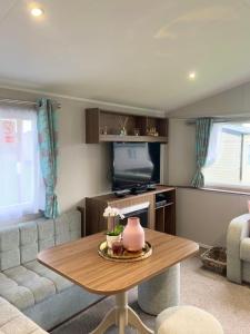 爱丁堡Lovely 3 bedroom holiday home in Seton Sand caravan park Wi-Fi Xbox的客厅配有桌子和沙发