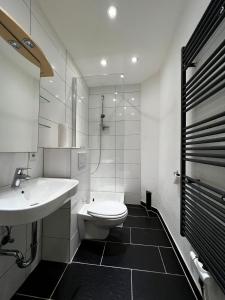 威斯巴登Ganze Wohnung Wiesbaden Stadtmitte 2 Zimmer Küche Bad mieten的白色的浴室设有水槽和卫生间。