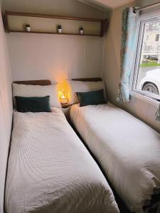 爱丁堡Lovely 3 bedroom holiday home in Seton Sand caravan park Wi-Fi Xbox的小型客房 - 带2张床和窗户