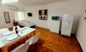 门多萨Mendoza Apartment的厨房配有桌椅和冰箱。