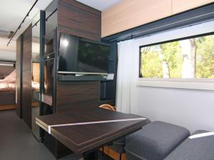 LütowDreamer luxury caravan on the backwaters, Lütow的一间带桌子和电视的小客厅