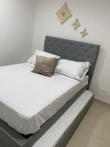 圣玛尔塔Apartment near to Bello Horizonte Beach, Santa Marta Airport的一张带白色床单和枕头的床