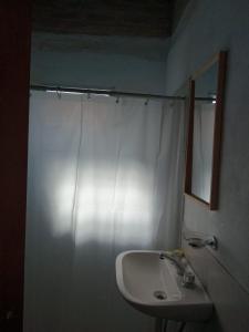 米娜克拉韦罗Madrenatura的浴室设有白色的淋浴帘和水槽