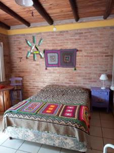米娜克拉韦罗Madrenatura的一间卧室设有一张床和砖墙