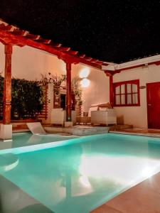 莱昂Hotel la Perla Leon的夜间在房子里的一个游泳池