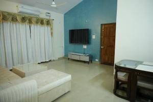 帕纳吉Shri Mahamaya的带沙发和电视的客厅