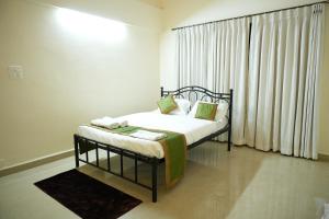 帕纳吉Shri Mahamaya的一间卧室配有床和带窗帘的窗户