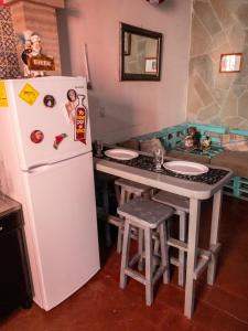 瓜纳华托Barranca12的厨房配有白色冰箱和带凳子的桌子