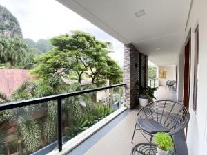 爱妮岛比尔旅游宾馆的阳台配有桌椅和树木。