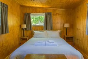 特卡波湖Mount Cook Station Huts的一间卧室配有一张床,上面有两条毛巾