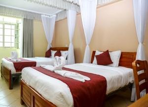 内罗毕Deka Self Contained Rooms的一间卧室配有两张红色和白色床单