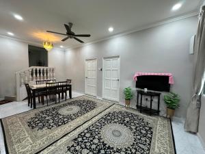 PedasD'beeba Homestay的客厅配有桌子和吊扇