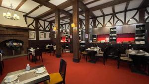 勒图凯-巴黎普拉日布里斯托尔酒店的一间带桌椅和壁炉的餐厅