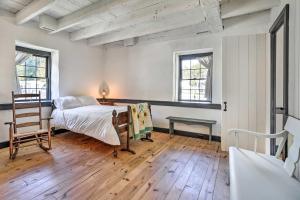 ThurmontHistorical Thurmont Escape with Furnished Deck!的一间卧室配有一张床、一张桌子和两个窗户