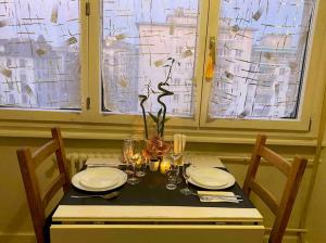 日内瓦Central & relaxed的一张桌子,上面有盘子和玻璃杯,上面有花瓶