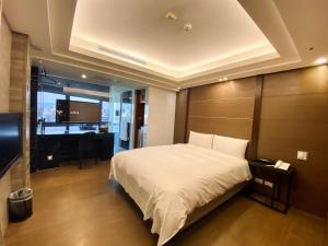 台北宝格利时尚旅馆的一间卧室配有一张床、一张书桌和一台电视