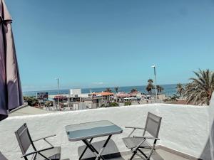 美洲海滩Studios CC Victoria Ocean View的海滩阳台的一张桌子和两把椅子
