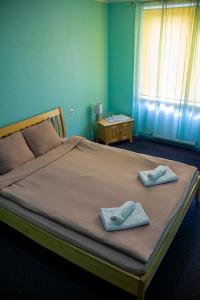 陶格夫匹尔斯Olimpija Hotel & SPA的一间卧室配有一张大床和两条毛巾