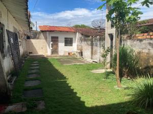 贝伦Casa de praia no Ariramba, Mosqueiro, Belém/PA.的一个带房子和栅栏的院子