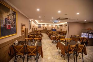 伊斯坦布尔Hamitbey Hotel Yenikapı的一间在房间内配有桌椅的餐厅