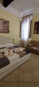 费拉拉DIMORA AL SARACENO的客房设有两张床、一张沙发和一个窗口。