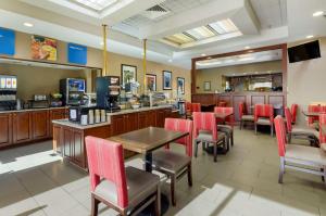 布莱克斯堡Comfort Inn Blacksburg University Area的餐厅设有红色的椅子、桌子和柜台