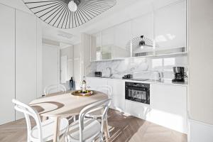 格但斯克GREAT Grano Residence的白色的厨房配有桌子和白色椅子