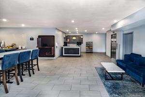 霍恩湖Days Inn & Suites by Wyndham Horn Lake - Memphis Graceland的一间带蓝色沙发的客厅和一间厨房