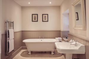 Lupton普拉夫宾馆的一间带大浴缸和水槽的浴室