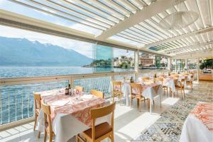 利莫内-苏尔加达Hotel Le Palme的一间带桌椅并享有水景的餐厅