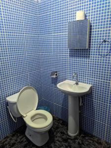 诺布里斯Pousada Canto das Araras - Vila Bom Jardim Nobres MT的蓝色瓷砖浴室设有卫生间和水槽