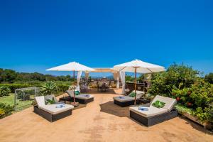 穆罗Ideal Property Mallorca - Els Moyans的庭院里摆放着一组椅子和遮阳伞
