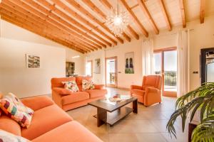 布格Es Puchet的客厅配有橙色家具和木制天花板