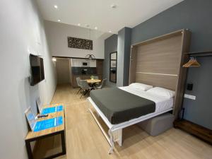 瓦伦西亚Travel Habitat Benimaclet Vista Hermosa Suites的一间带大床的卧室和一间餐厅