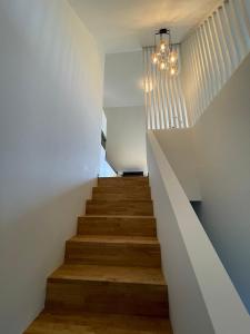 ZoutleeuwVakantieappartement Logies Terhagen的房屋内的楼梯,拥有白色的墙壁和木地板
