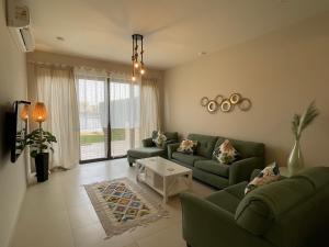 赫尔格达Luxury 3BR Townhouse, Tawila, El Gouna, Lagoon & Pool access的客厅配有两张绿色沙发和一张桌子